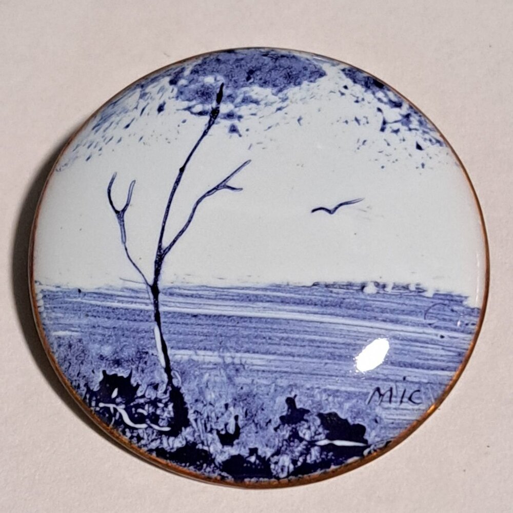 vintage round circle brooch with a blue and white landscape design open field